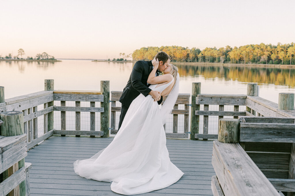 Image of bride and groom kissing on a dock.